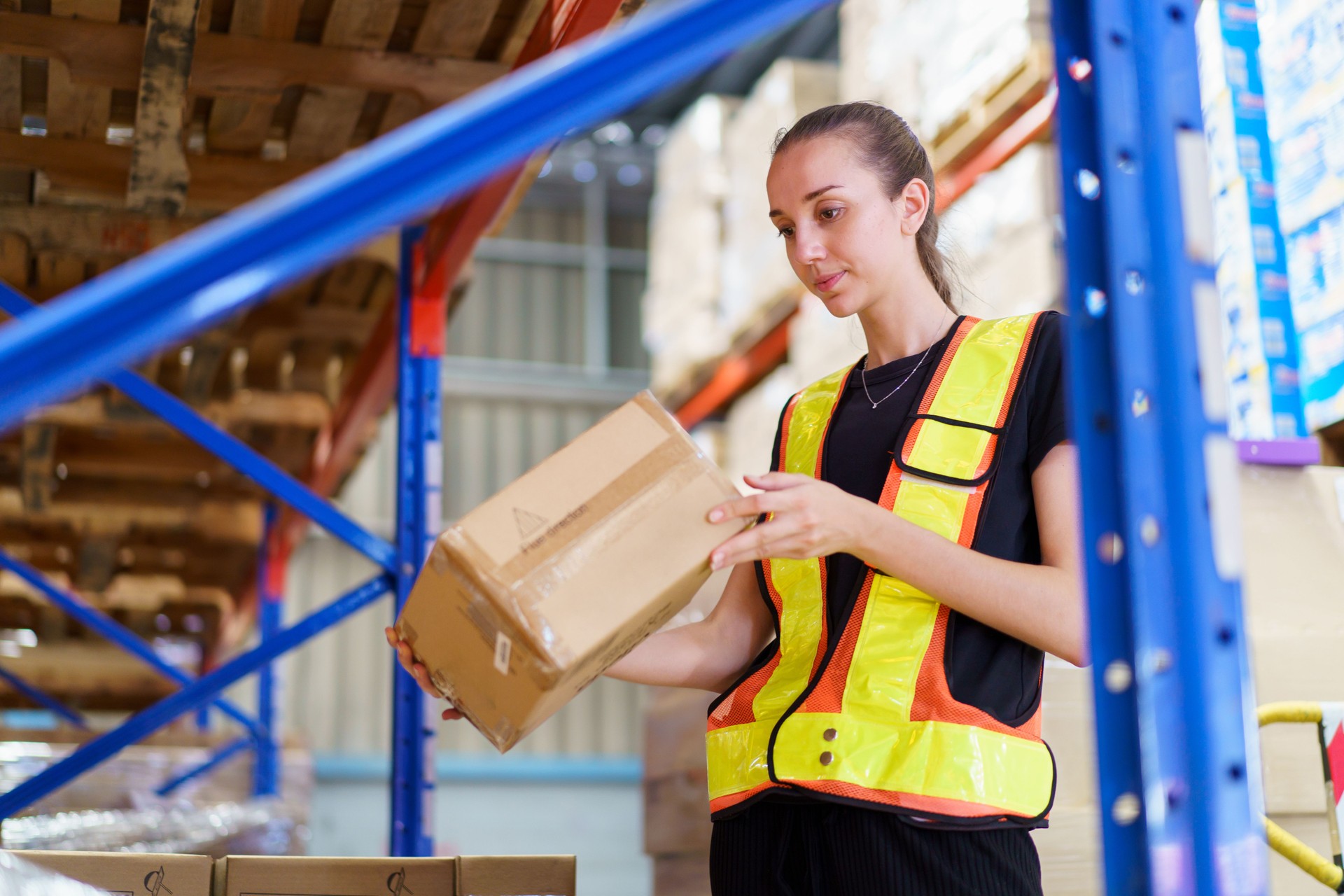 Female caucasian white warehouse worker inspecting the inventory.